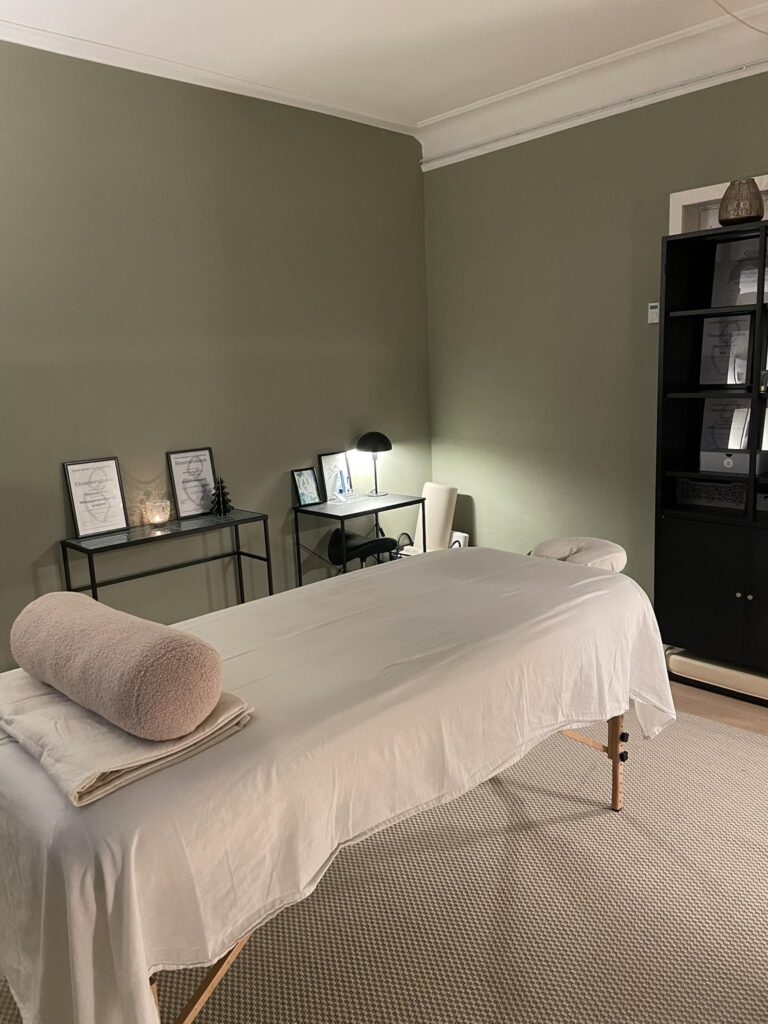 Roligt massagerum med behandlingsbriks og dæmpet belysning
