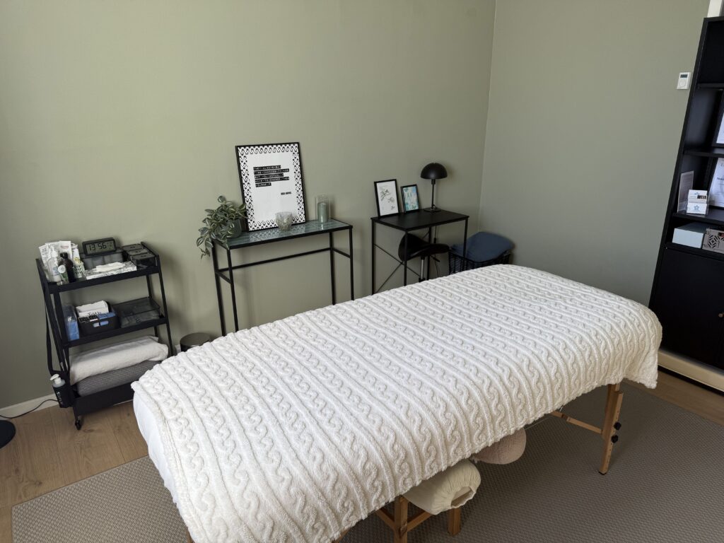Rolig massageklinik med behandlingsbriks og minimalistisk indretning